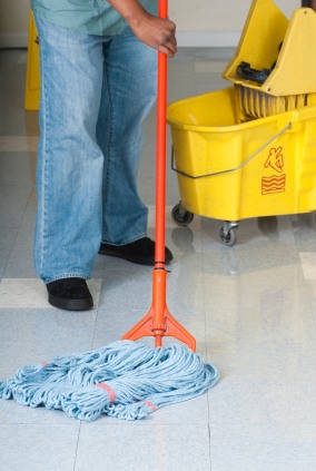 Reliable Cleaning Services LLC janitor in Walbrook, MD mopping floor.